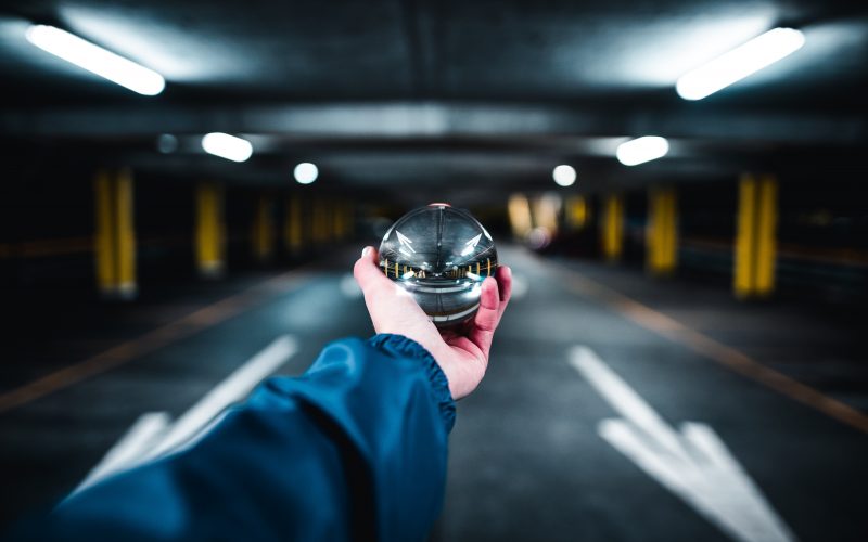person holding grey glass ball