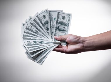 person holding 100 US Dollar banknote