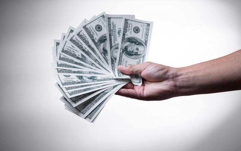 person holding 100 US Dollar banknote