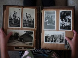 person opening photo album displaying grayscale photos