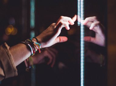 person wearing silver bracelet holding a light