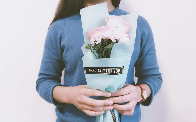 woman holding pink flower bouquet