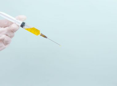 person holding clear glass bottle