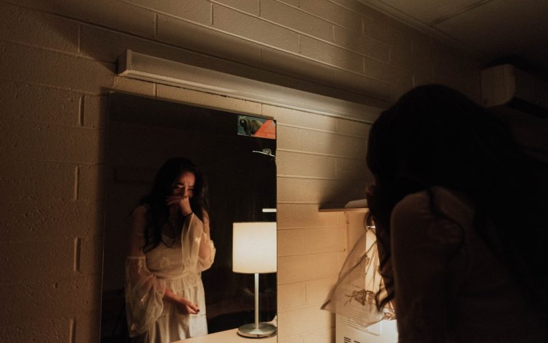 woman crying in front of mirror