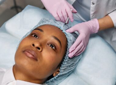 Close-up of a cosmetic procedure using injectables on a woman's forehead in a clinic setting.